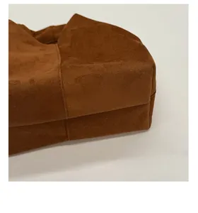 Detailed view of the stitched bottom base and suede texture of the brown cloud bag