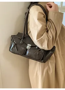 Deep brown retro faux leather shoulder bag with silver hardware on a khaki trench coat