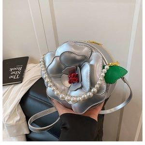 Detail of silver floral circular bag with 3D petals and elegant pearl handle strap