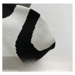 Macro shot of black and white wavy striped knit texture on a shell-shaped crossbody bag