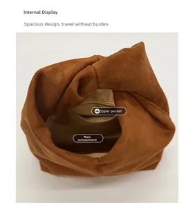 Interior view showing spacious main compartment and zipper pocket of brown suede cloud bag