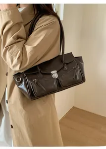 Detail of dark brown faux leather tote bag with zip pockets and metal rotary lock