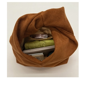 Top view of spacious brown suede cloud bag interior showing tablet and storage capacity