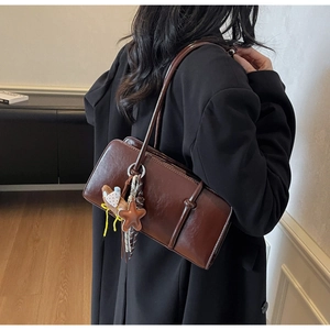 Gros plan sac bandoulière marron avec breloque étoile et glands décoratifs