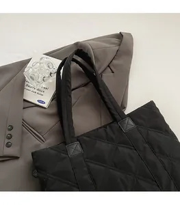 Dettaglio della borsa tote in nylon nero trapuntato con cuciture rinforzate e motivo a rombi