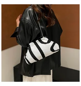 Detail of knitted jacquard cloud bag with black and white patterns and chain strap