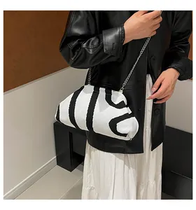 Knitted chain shell bag with geometric patterns worn with a stylish outfit
