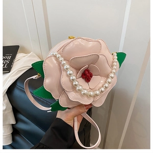 Detailed view of pink camellia petal leather handbag with elegant pearl chain strap