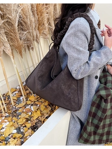Details der dunkelbraunen Wildleder-Hobo-Tasche mit Faltenriemen für das Herbst-Styling
