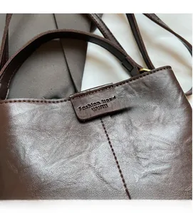 Close-up of dark brown leather bucket bag with litchi texture and precise vertical stitching