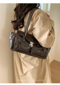 Detail of retro dark brown shoulder bag with zip pockets and metallic buckle closure