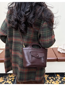 Retro dark brown bucket bag shown styled with a plaid wool coat in autumn setting