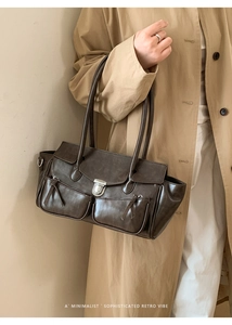 Detail shot of the vintage dark brown tote bag with metal buckles and zipper pockets