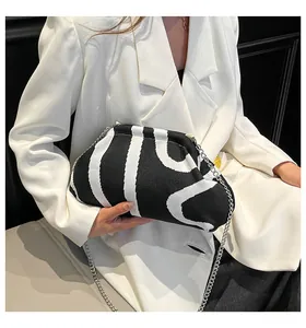 Detail of black and white wavy striped knit bag with elegant silver chain strap