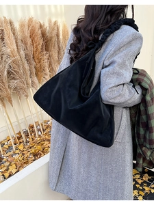 Detail of black matte leather tote bag with pleated ruched strap for autumn commute