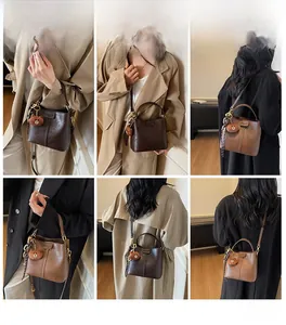 Detail of vintage bucket bag with leather texture and cute brown teddy bear charm