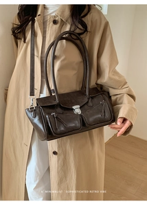 Detail of dark brown leather tote featuring dual front pockets and silver buckle closure