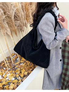 Detail des schwarzen gefalteten Schultergurts und der Textur einer Shopper-Tasche