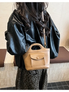 Caramel bucket bag with textured leather and front flap pocket shown in a lifestyle setting