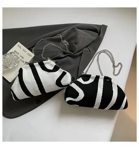 Close-up of knit shell bags with striped geometric patterns and silver chain straps