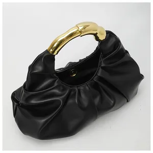 Detail of black pleated cloud bag featuring an irregular golden metal organic handle