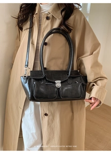 Detail view of retro black shoulder bag with two front pockets and silver metal buckles