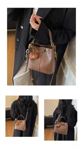 Detail view of brown vintage bucket bag with leather texture and cute plush bear charm