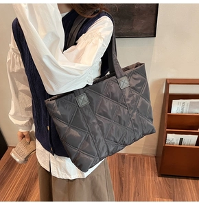 Dettaglio della borsa tote trapuntata grigio scuro in nylon leggero con cuciture a rombi