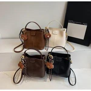 Detail view of four vintage bucket bags with bear pendants and woven rope accents