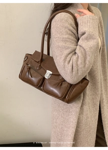 Macro detail of dark brown retro shoulder bag showing silver metal buckle and pockets