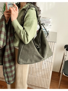 Detailansicht der olivgrünen Hobo-Bag mit plissiertem Riemen und matter Ledertextur