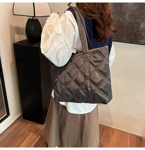 Close-up of black quilted tote bag with diamond stitching and soft padded texture