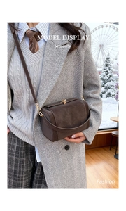 Close-up of brown vintage suede crossbody bag with elegant metal turn-lock closure