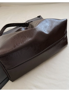 Close-up of deep brown oil-wax leather texture with shiny finish and soft grain details