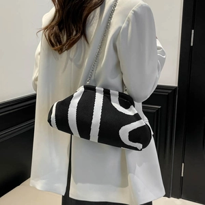 Minimalist black and white knitted shell bag with silver chain strap shown on model