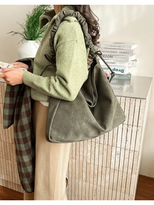 Detailaufnahme der olivgrünen Wildleder-Tote-Bag mit gerafftem Gurt und Schnürdetails