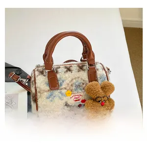 Close-up of contrast faux fur Boston bag with leather handles and bear pendant
