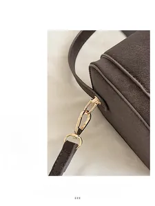 Detailed close-up of dark brown lychee grain leather with premium gold metal hardware clasp