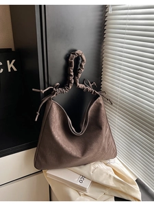 Detailansicht der dunkelbraunen Hobo-Tasche mit Falten-Griff und Kordelzug-Schleifen