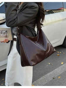 Close-up of deep brown large tote bag in wrinkled vintage leather on street background