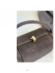 Close-up of vintage brown leather shoulder bag featuring elegant gold metal twist lock buckle