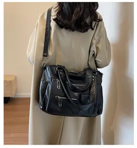 Detailed look at a black multi-pocket tote bag worn over a beige trench coat