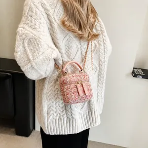 Tweed mini chain box bag in pink featuring elegant gold hardware on a model