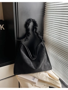 Detailansicht der schwarzen matten Ledertasche mit gerafftem Cloud-Griff-Design