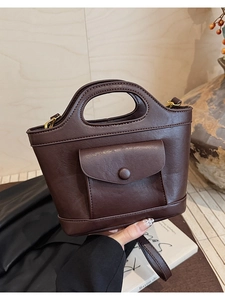 Detail of dark brown lychee texture leather mini bag with vintage gold hardware