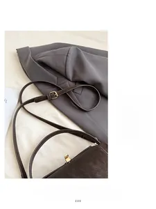 Close-up of sleek shoulder strap and gold adjustment buckle on a vintage suede bag