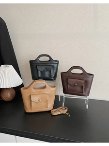 Three PU leather bucket bags in black and brown on acrylic stands in a home setting