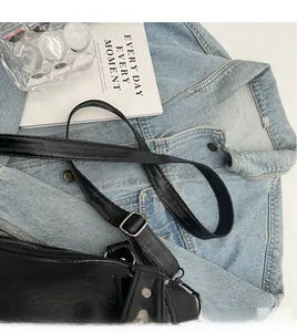 Detailed texture of black vintage PU leather handbag with adjustable silver buckle