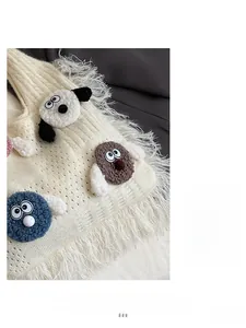 Close-up of cream knit tote bag with fluffy trim and cute cartoon monster patches