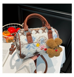 Detail of plush Boston bag featuring cow pattern textures and fuzzy bear charm